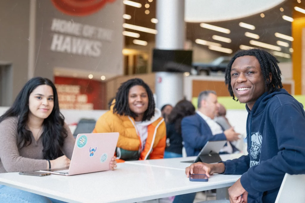 The guys are sitting around the table smiling